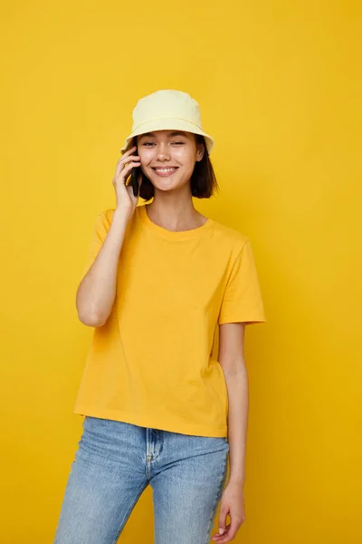 Young beautiful woman in a yellow hat Youth style casual talking on the phone isolated background — Φωτογραφία Αρχείου