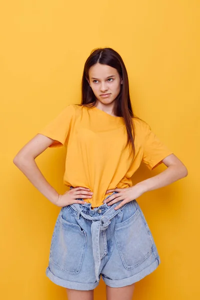 Νεαρή όμορφη γυναίκα μόδας σε κίτρινο t-shirt denim σορτς απομονωμένο φόντο — Φωτογραφία Αρχείου