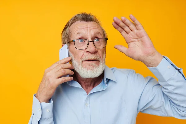 Retrato anciano hablando por teléfono emociones amarillo fondo —  Fotos de Stock