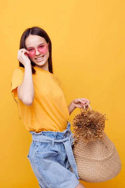 Foto menina bonita Praia saco moda em amarelo t-shirt denim shorts fundo amarelo — Fotografia de Stock