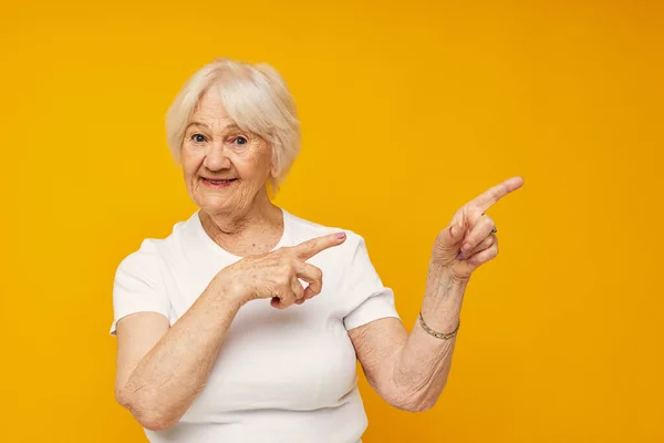 Usmívající se starší žena v neformálních gestech trička s vystřiženým pohledem — Stock fotografie
