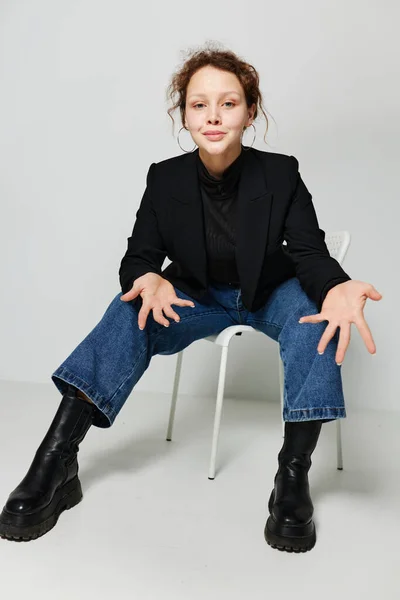 Красивая женщина черная куртка джинсы позировать светлый фон без изменений — стоковое фото