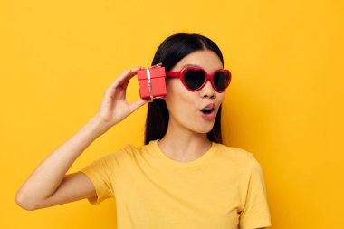 Güzel esmer moda gözlükleri hediye tatil sarı arka plan değiştirilmemiş