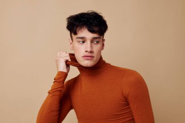 Yakışıklı adam kahverengi balıkçı yaka. Moda arkaplan pozu veriyor.