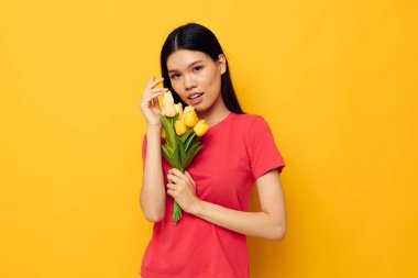 Kırmızı tişörtlü tatlı Asyalı kız bir buket çiçekle