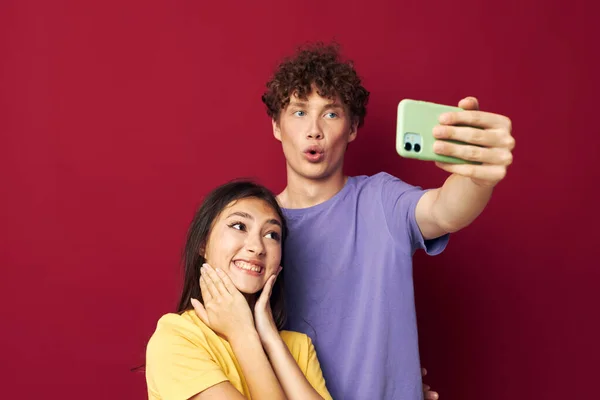 Joven hombre y chica tomar un selfie posando abrazo aislado fondo — Foto de Stock