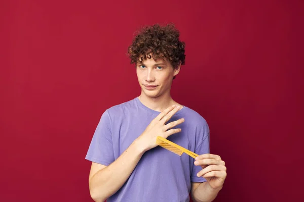 Portrét mladého kudrnatého muže v purpurových tričkách s hřebenem Mládežnický styl — Stock fotografie