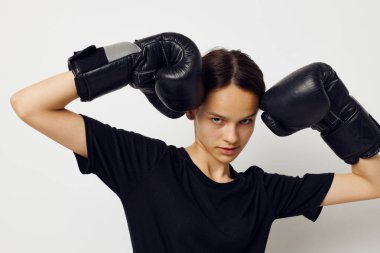 Siyah pantolonlu boks eldivenli atletik bir kadın ve bir tişört fitness eğitimi.