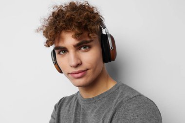 Kulaklıkla müzik dinleyen yakışıklı genç bir adam. Duyguları izole edilmiş.