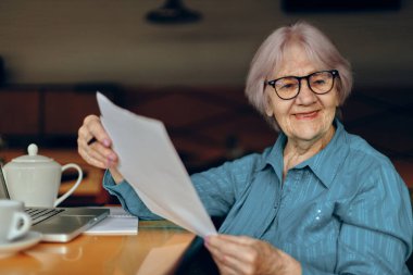 Güzel olgun yaşlı bir kadın bir kafede bir bardak laptopla emekli bir kadın değişmeden sohbet ediyor.