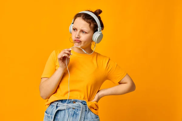 헤드폰 청소년 스타일의 노란색 배경 음악을 듣고 있는 아름다운 여성 — 스톡 사진