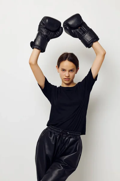 Mujer atlética en guantes de boxeo en pantalones negros y una camiseta de fondo aislado —  Fotos de Stock