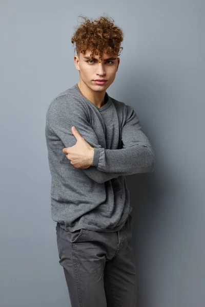 Stilig ung man i en grå tröja mode studio isolerad bakgrund — Stockfoto