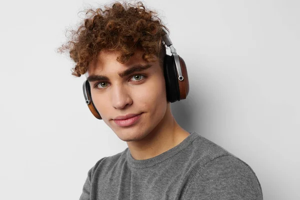 Joven guapo escuchando música en auriculares emociones aisladas fondo — Foto de Stock