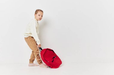 Kafasında şapka olan sevimli kız okul çantası. Yaşam tarzı değişmemiş.