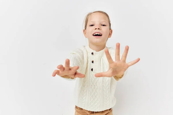 Kleines Mädchen in einem weißen Pullover stilvolle Kleidung hellen Hintergrund — Stockfoto