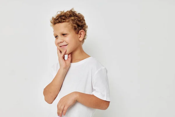 Ricci ragazzo in un bianco t-shirt posa divertimento infanzia inalterato — Foto Stock
