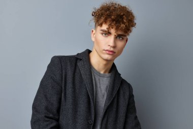 Gri kazaklı yakışıklı genç adam. Moda stüdyosu izole edilmiş.