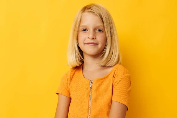 Kid girl in a yellow t-shirt smile posing studio color background unaltered — Stock Photo, Image