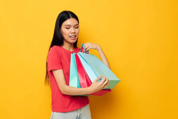 Portrait Asian beautiful young woman shopping bags in red t-shirt isolated background unaltered — Stock Photo, Image
