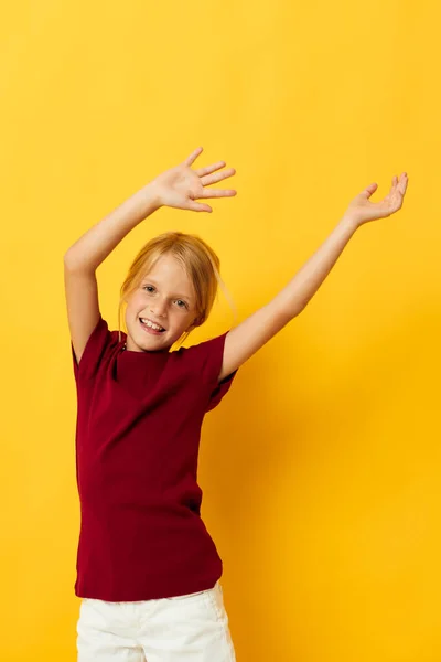 Vrolijk meisje met blond haar gebaren met haar handen geel achtergrond — Stockfoto