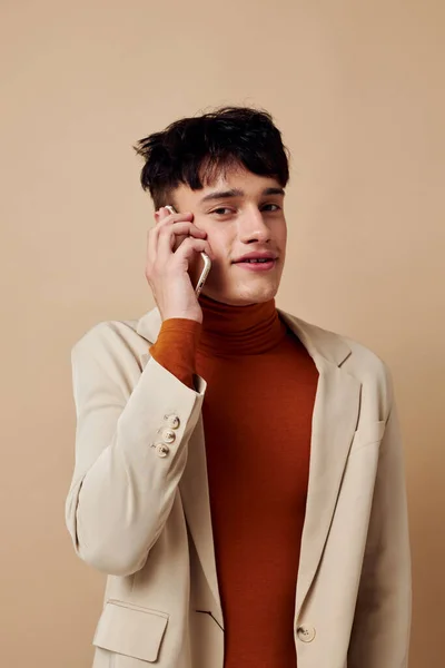 Foto joven novio en una chaqueta beige hablando por teléfono Estilo de vida inalterado — Foto de Stock