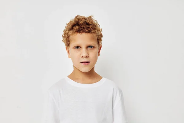 Foto di giovane ragazzo in una t-shirt bianca posa divertente infanzia inalterata — Foto Stock