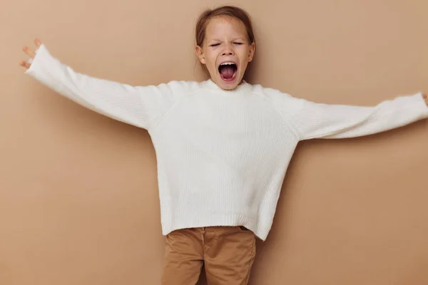 Portrait of happy smiling child girl joy posing emotions fashion beige background — Stockfoto