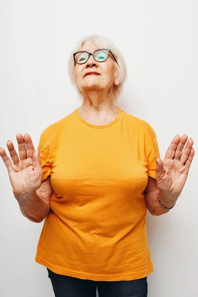 Starší žena v ležérní tričko a brýle izolované pozadí — Stock fotografie