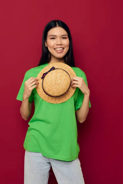 Encantador jovem asiático gestos mulher com as mãos com um chapéu em um verde t-shirt estúdio modelo inalterado — Fotografia de Stock