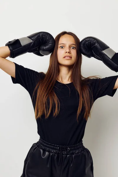 Beautiful girl in boxing gloves punch in black pants and a T-shirt fitness training — Stock Photo, Image