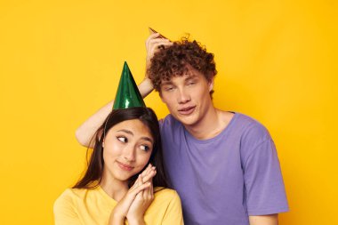 Şapkalı genç çift tişörtleri çok renkli.