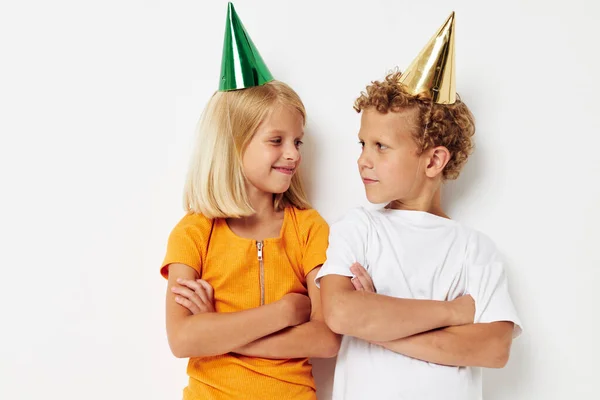 Portret uroczych dzieci stwarzających emocje wakacje kolorowe czapki lekkie tło — Zdjęcie stockowe