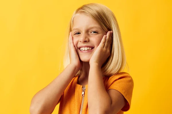 Cute little girl with blond hair posing yellow background — Stockfoto