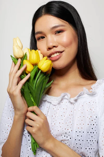 Okouzlující mladá asijská žena v bílé košili květiny jaro představovat studio modelu beze změny — Stock fotografie