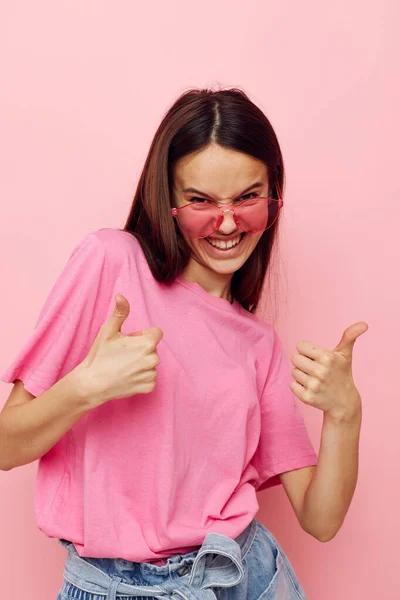 Mujer positiva gafas de color rosa y camiseta gesto de mano aislado fondo — Foto de Stock