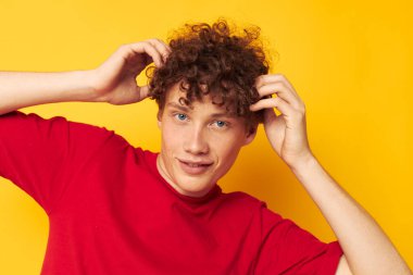 Kıvırcık saçlı genç adam yaz modasına uygun olarak izole bir arka plan oluşturdu.