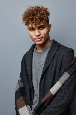 Yakışıklı genç adam. Siyah ceketli. Modadan soyutlanmış.