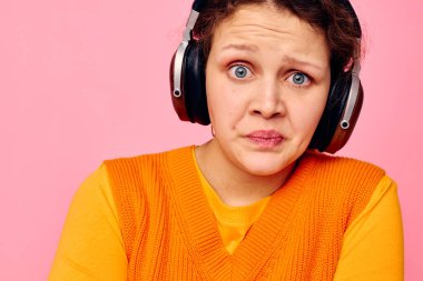 Turuncu kulaklıklı güzel bir kadın müzik dinletisi değiştirilmemiş bir manzara.