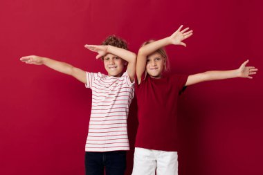 Hoş, şık çocuklar gülümsüyor ve izole edilmiş arka planda günlük kıyafetlerle poz veriyorlar.