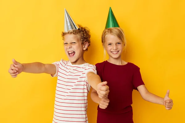 Diversión de vacaciones para niños pequeños con gorras en su cabeza fondo amarillo —  Fotos de Stock