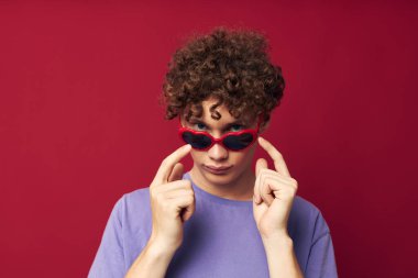 Kıvırcık saçlı genç adam yaz tarzı güneş gözlükleri izole edilmiş arka plan.