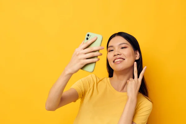 Donna con un telefono in mano fa un modello di studio selfie inalterato — Foto Stock