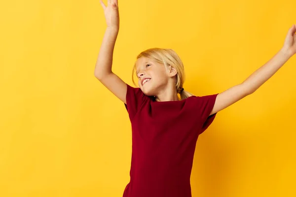 Vrolijk meisje met blond haar gebaren met haar handen geel achtergrond — Stockfoto