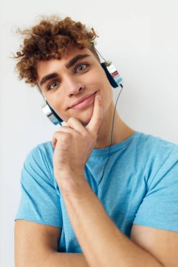 Mavi tişörtlü yakışıklı adam kulaklıklı moda arkaplanı.
