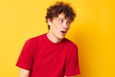 Kıvırcık saçlı genç adam yaz modasına uygun olarak izole bir arka plan oluşturdu.