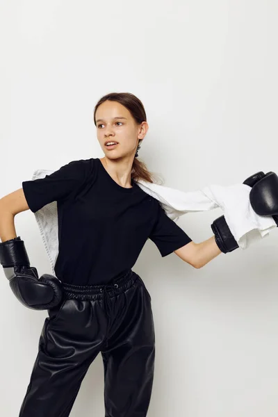 Hermosa chica en guantes de boxeo en pantalones negros y una camiseta estilo de vida inalterable —  Fotos de Stock
