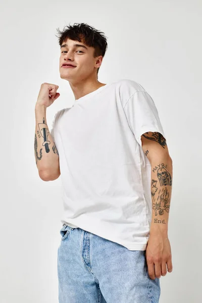 Man modern ungdom stil vit t-shirt tatuering på armen modell studio — Stockfoto