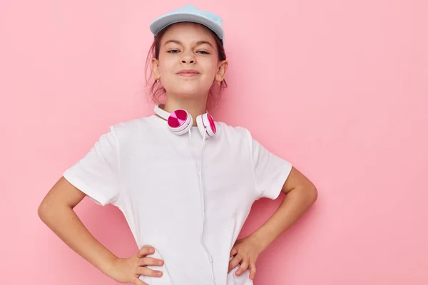 Auriculares de niña bonita en una camiseta blanca y una gorra Lifestyle inalterada — Foto de Stock