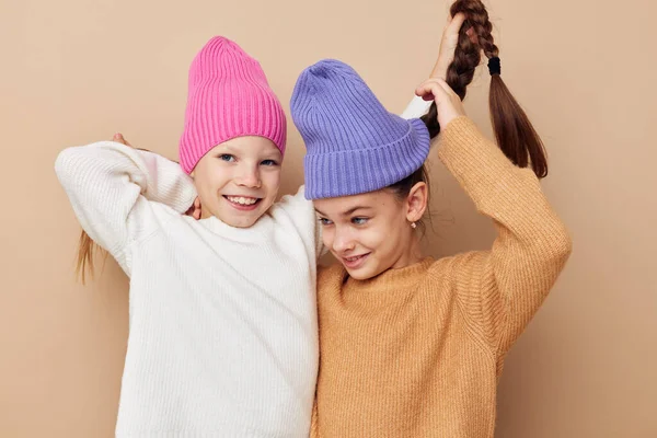 Δύο μικρά κορίτσια στέκονται το ένα δίπλα στο άλλο με καπέλα συναισθήματα μόδας — Φωτογραφία Αρχείου